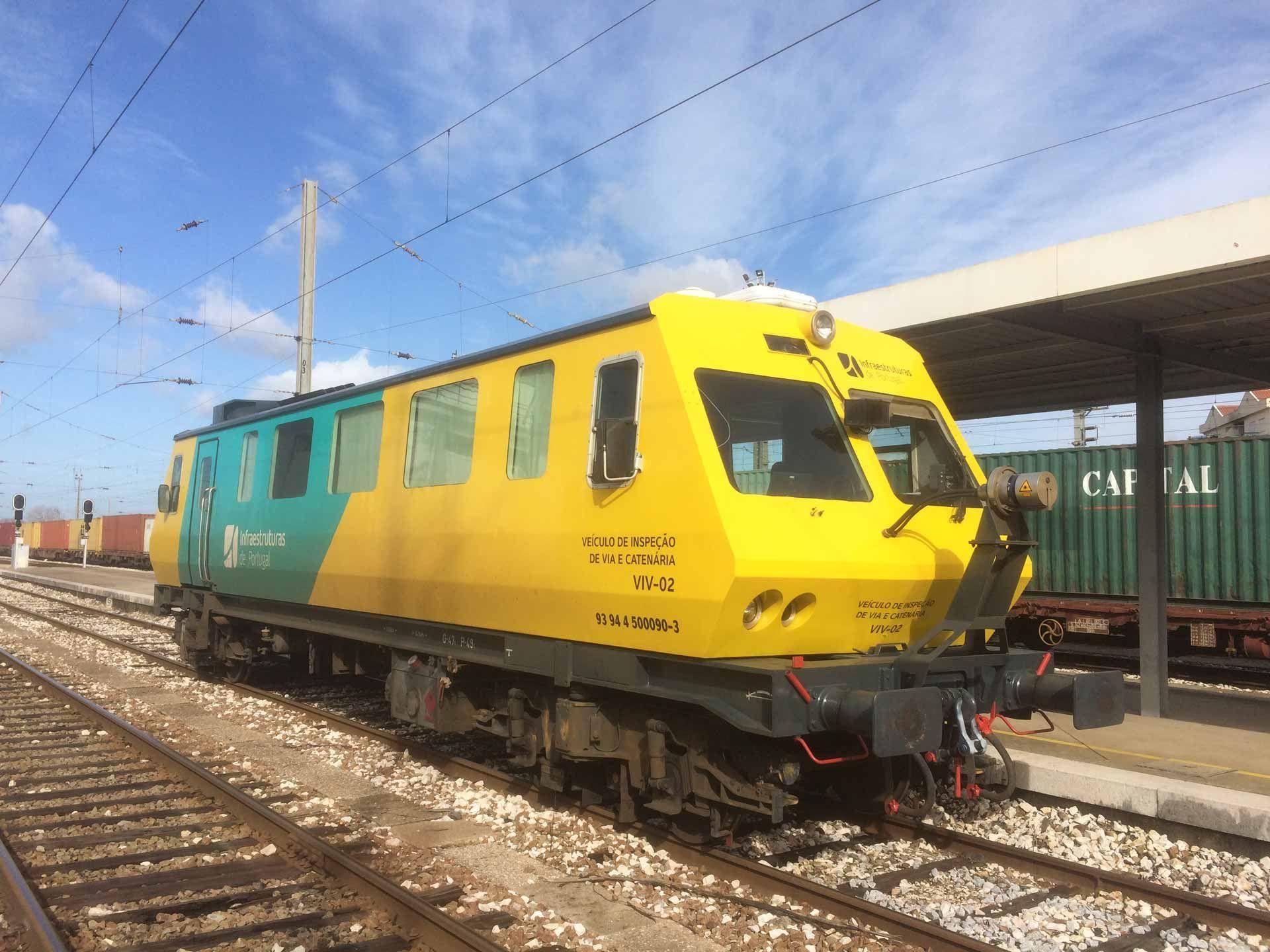 Ein gelber Eisenbahnwagen an einer Bahnhaltestelle in Portugal
