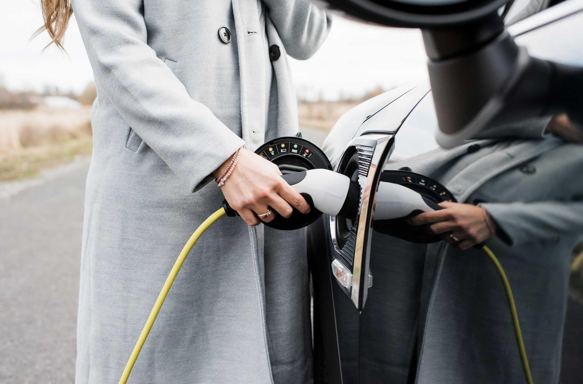 Woman charging her electric vehicle