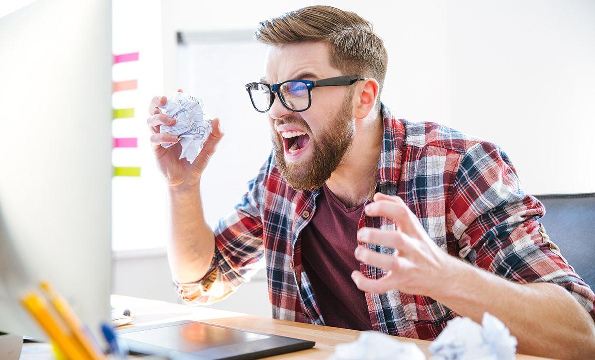 Screaming and angry software developer in front of Computer