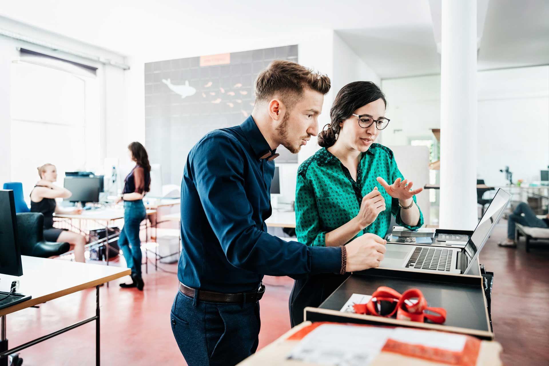 Two employees in an office collaborating on a project