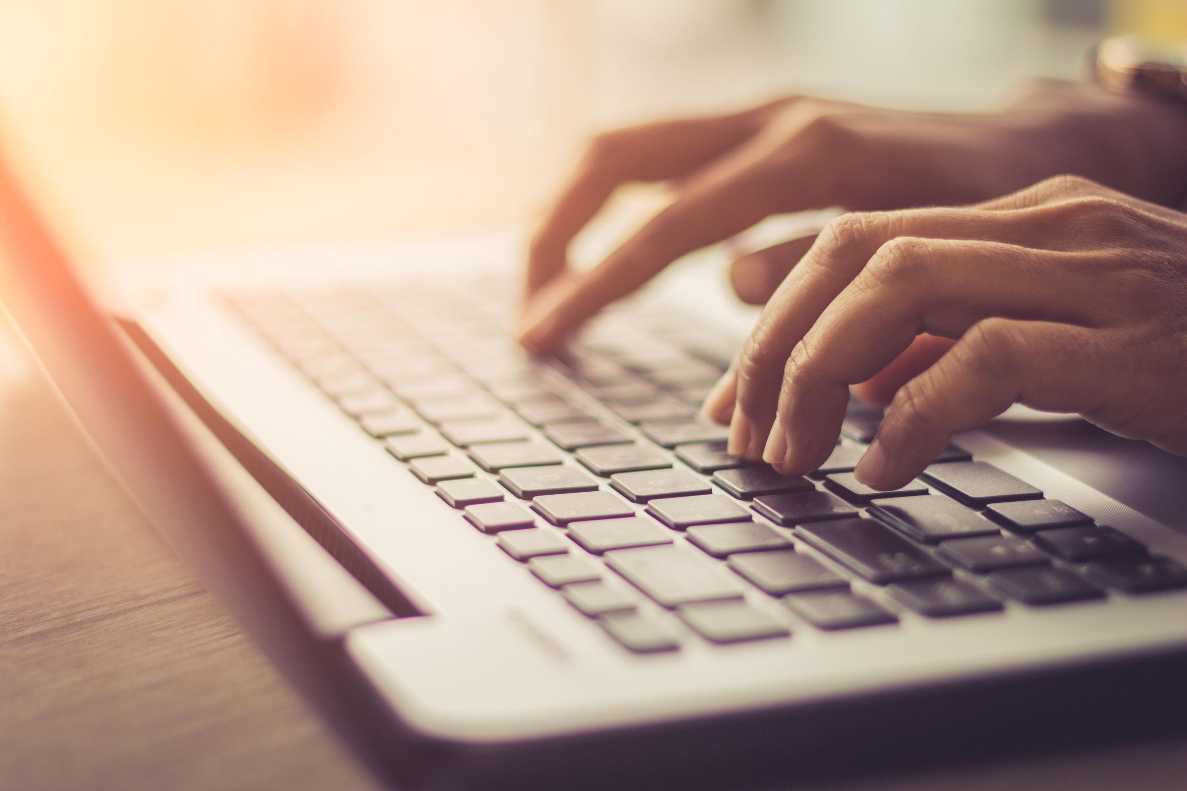 Hands on a laptop keyboard