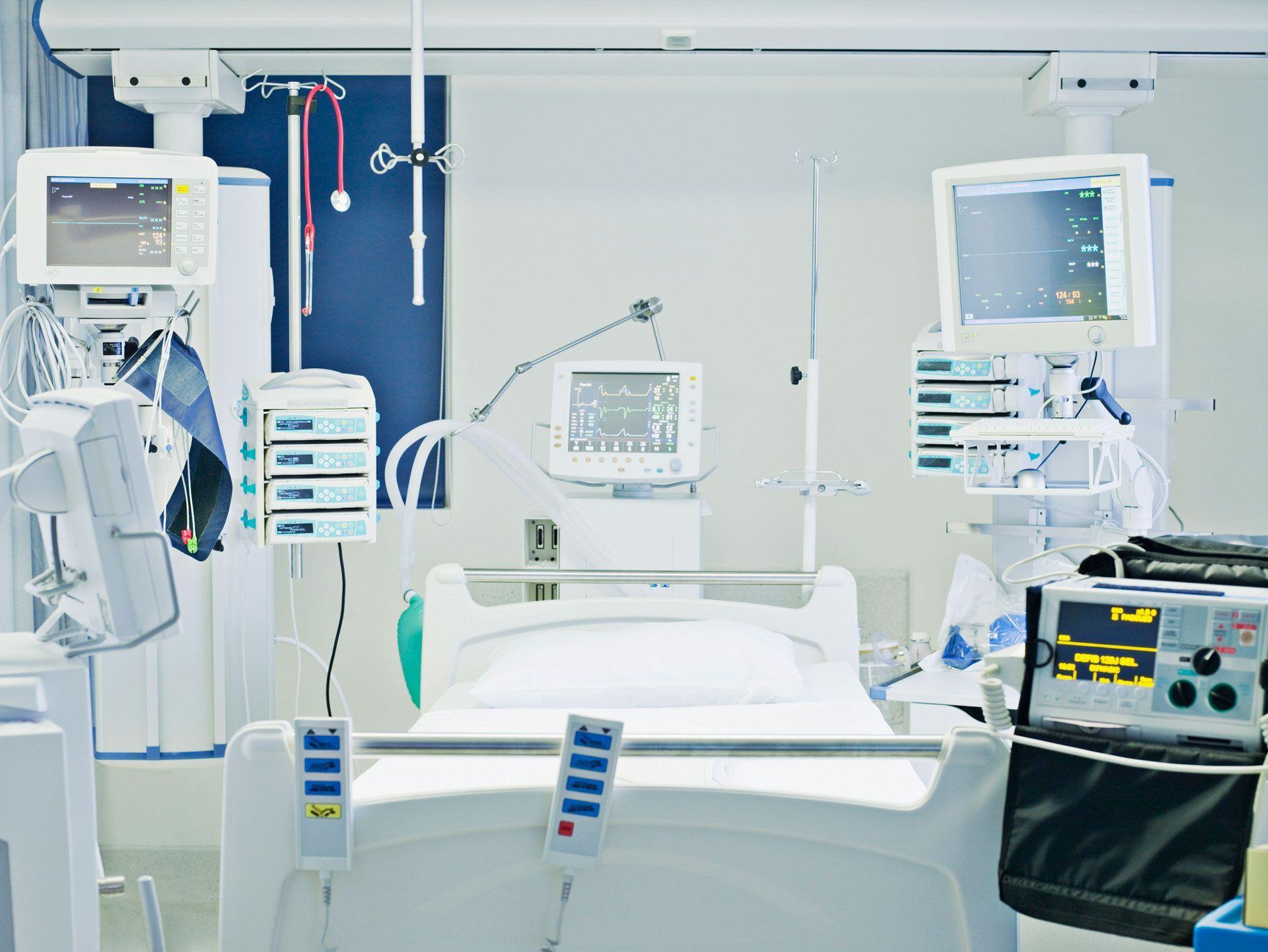 Krankenhauszimmer mit Bett und verschiedenen medizintechnischen Geräten