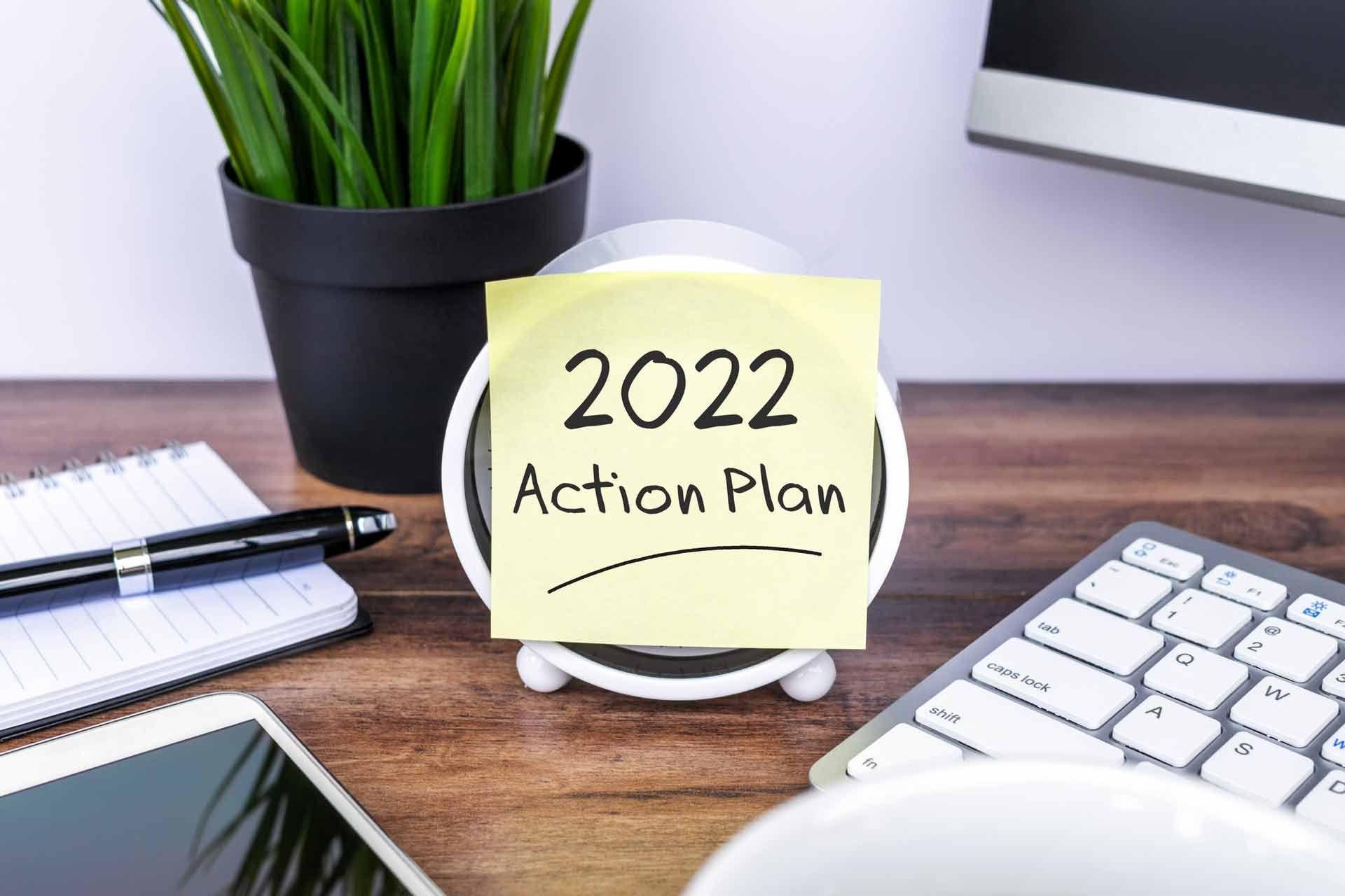 Desk with a post it that says 2022 action plan