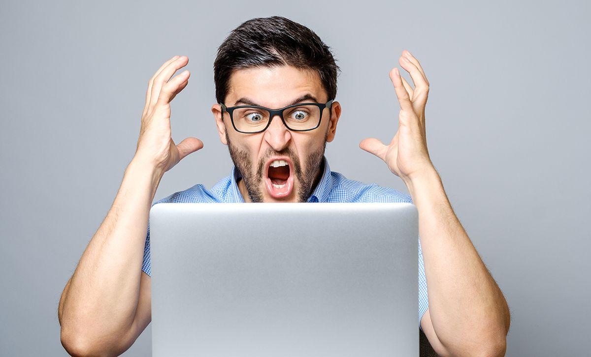 Angry man in front of a laptop